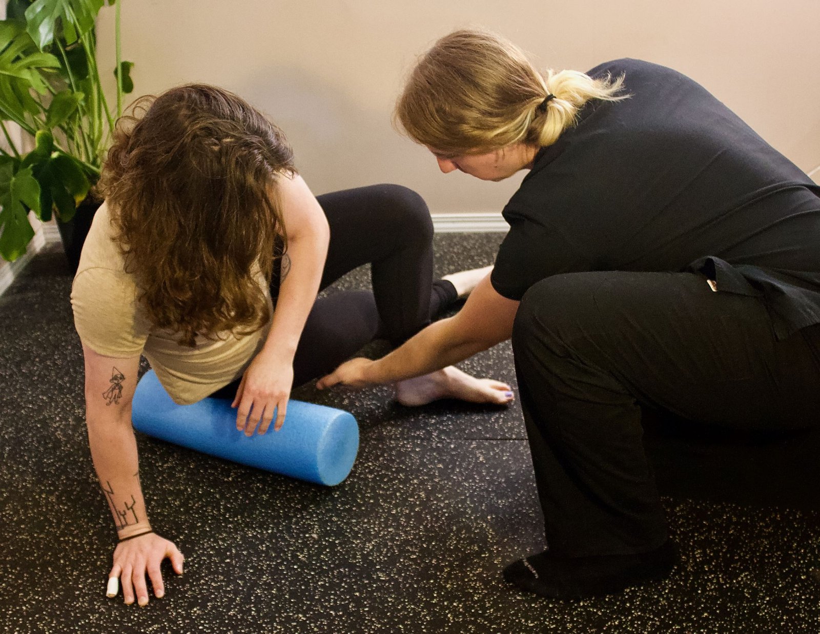 Marci showing a client a foam roller exercise to do at home